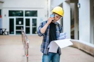 Construction worker using mobile devices for health and safety reporting on site