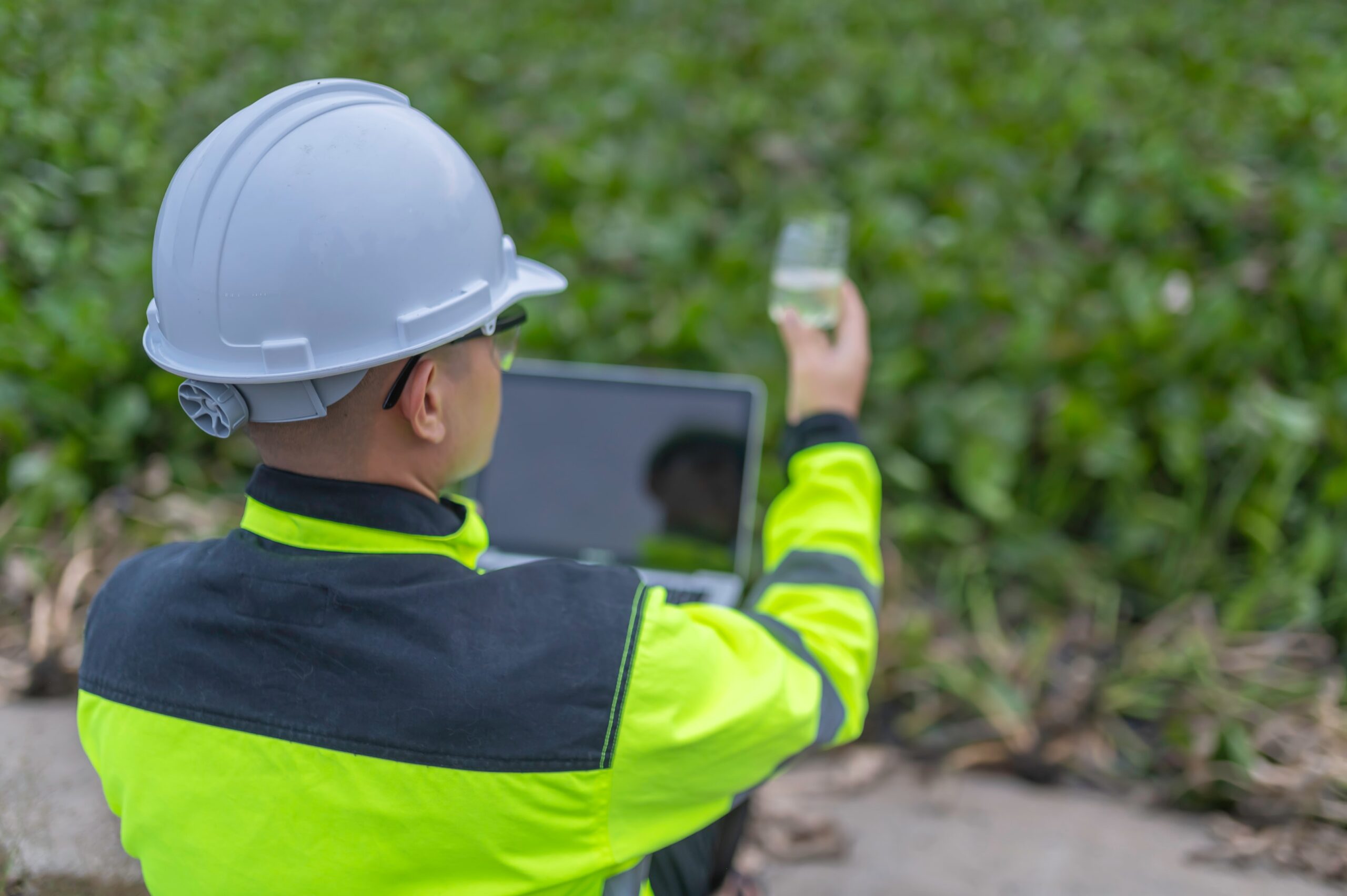 Environmental auditor checks water quality using an environmental audit checklist.